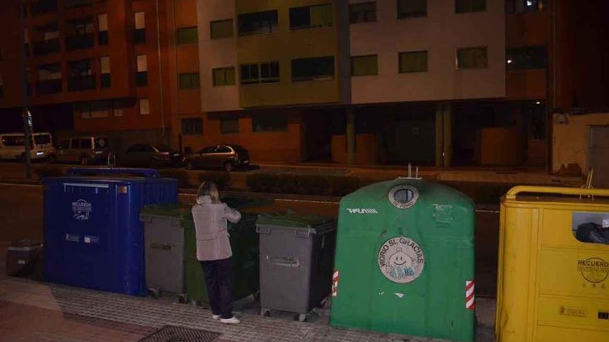 Una vecina deposita una bolsa de basura en uno de los contenedores de la avenida Luis Morán.