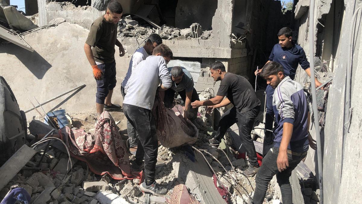 Un grupo de gazatíes trata de rescatar a las personas bajo los escombros tras un ataque israelí.
