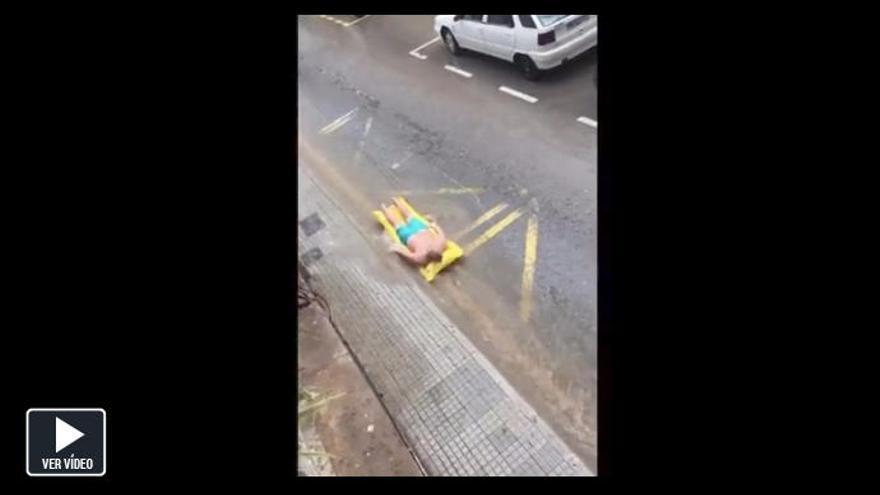 Surf con colchoneta en la calle tras las lluvias en Mallorca