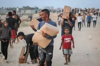 Los palestinos desplazados recogen la ayuda alimentaria que entró en el sur de la Franja de Gaza.