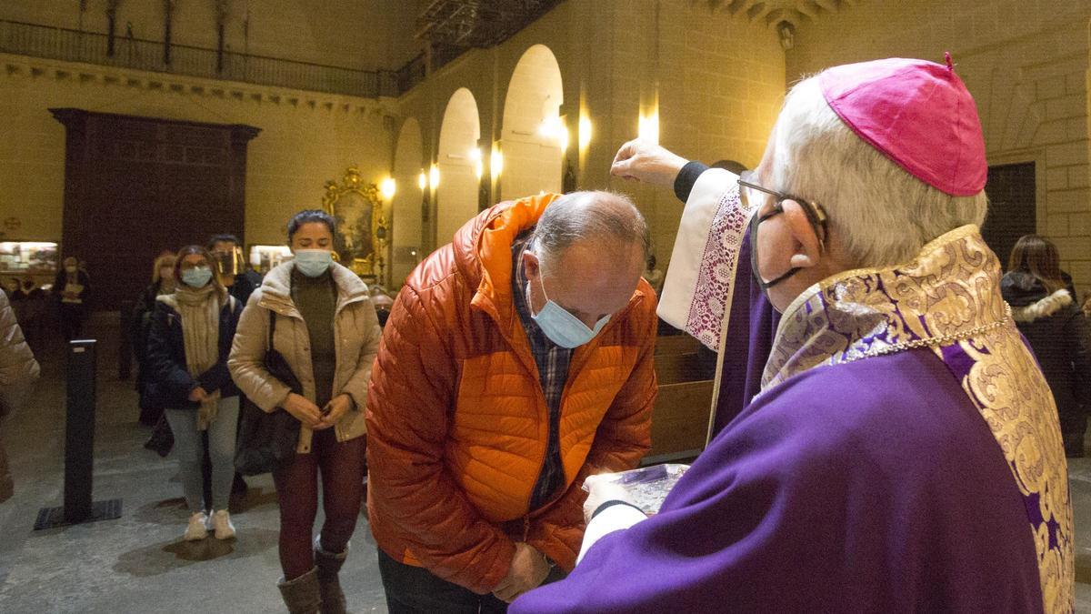 El obispo esparce la ceniza sobre la cabeza de un feligrés, esta tarde