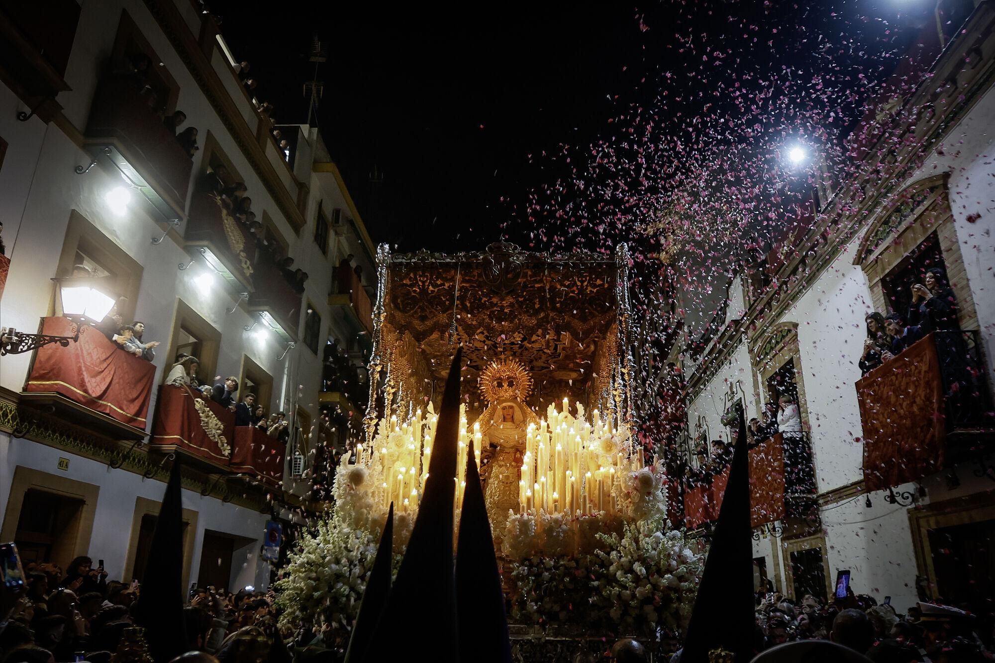 GRAFAND7862. SEVILLA, 18/04/2025.- La Virgen Esperanza de Triana de la Hermandad Sacramental del Stmo. Cristo de la Tres Caídas y Nuestra Señora de la Esperanza recorre las calles de Triana donde le arrojan pétalos de flores tras su salida de la Capilla de los Marineros para su estación de penitencia en La Madrugá esta noche en Sevilla.EFE /José Manuel Vidal