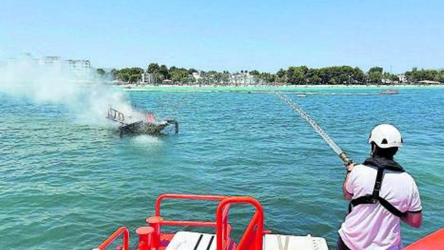 Personal de Salvamento extinguiendo un incendio que destruyó una embarcación en Alcúdia.