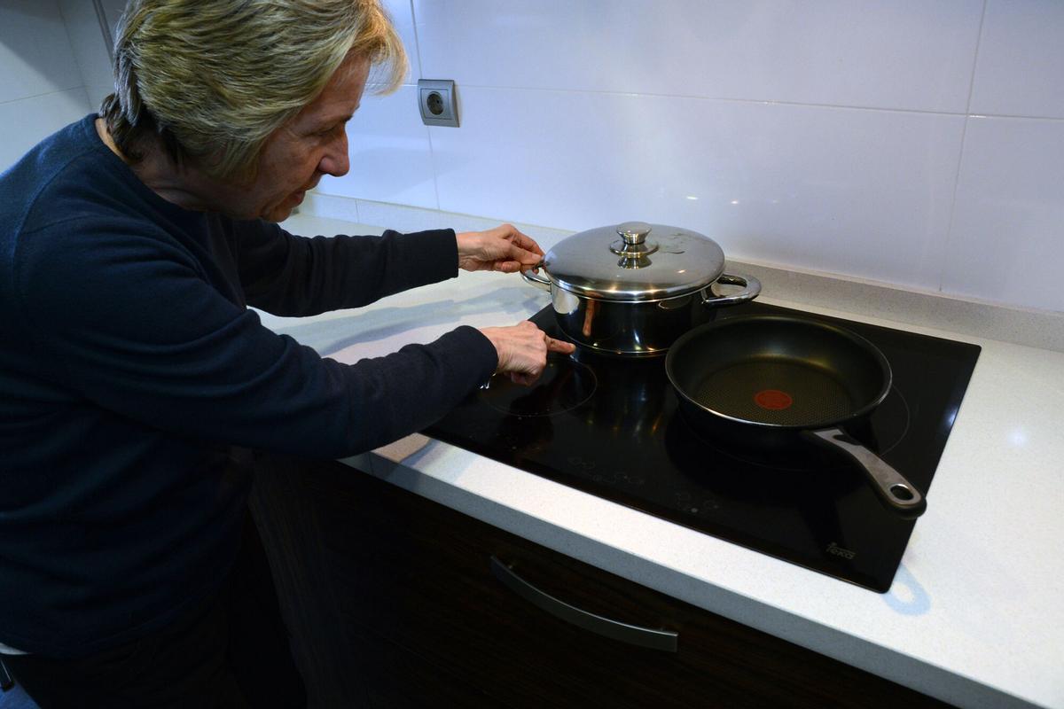 Una mujer cocina con una placa de inducción.