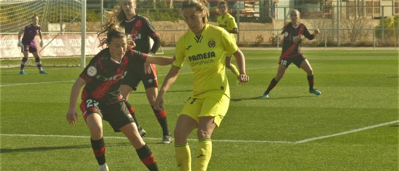 La jugadora amarilla Estefa Lima conduce un balón ante la presión de la vallecana María Bores en un lance del juego.