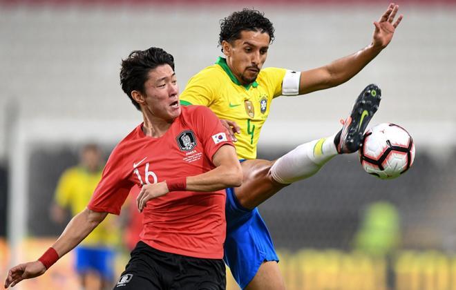 Marquinhos se enfrenta por el balón con Hwang Ui-jo durante el partido amistoso que ha enfrentado a las seleccions de Brasil y de Corea del Sur en el Estadio Mohammed Bin Zayed en Abu Dhabi.