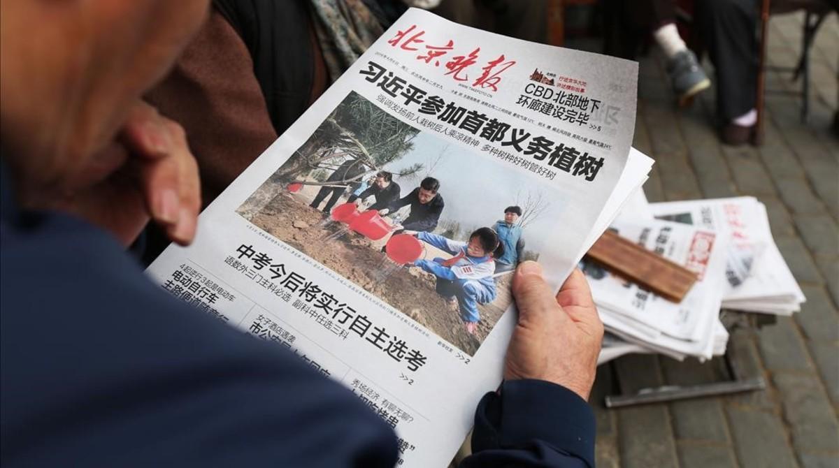 mbenach33435094 a man reads a newspaper featuring a front page pho160407172250