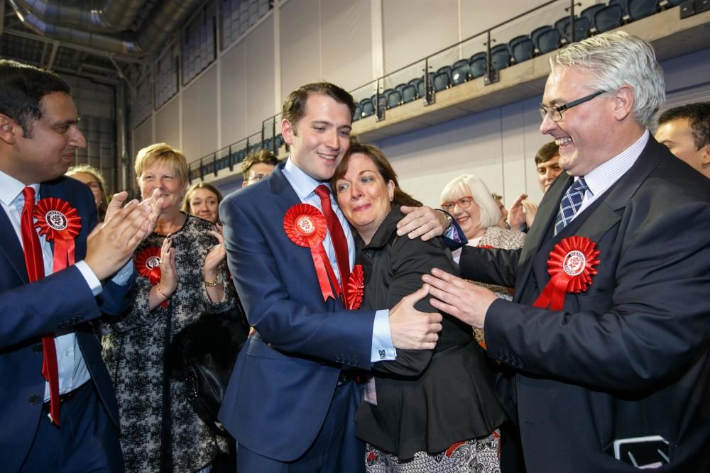 El nuevo miembro del Parlamento del Partido Laborista de Glasgow del Este Paul Sweeney (c-i) abraza a su madre, Anne Sweeney (c-d).