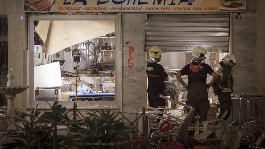 Bomberos inspeccionan el lugar de la explosión.