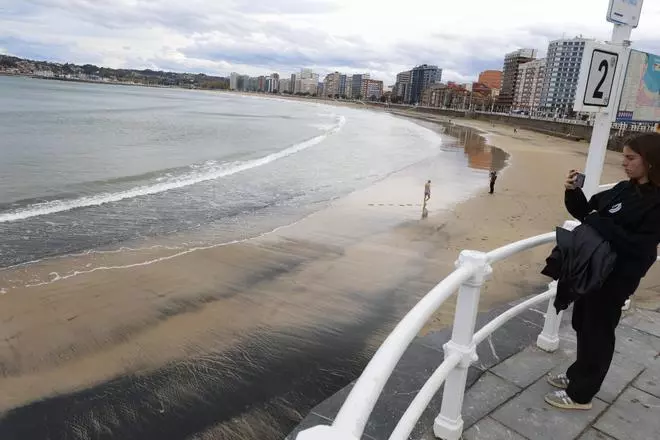 La playa de San Lorenzo en Gijón vuelve a teñirse de negro por culpa del carbón (en imágenes)