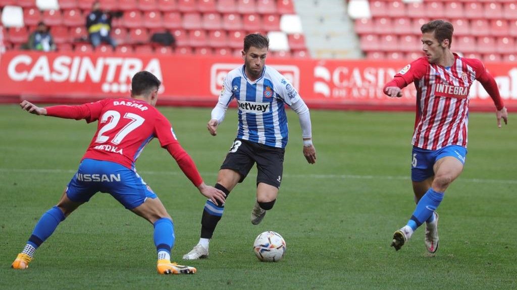 Embarba intenta escaparse de dos jugadores del Sporting.