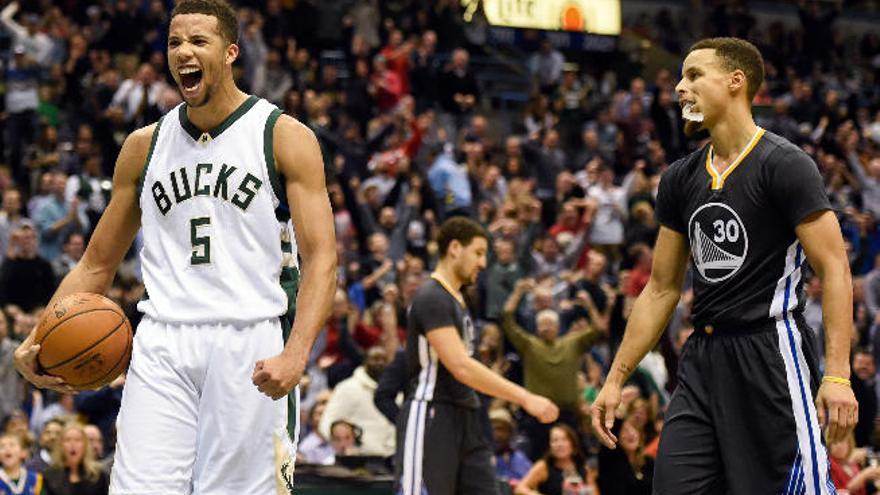 Carter-Williams celebra una canasta de los Bucks, con Curry a la derecha.