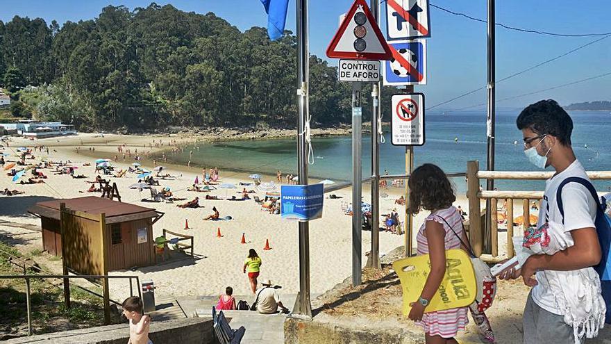 Bañistas el pasado verano en la playa de Mogor.   | // RAFA VÁZQUEZ