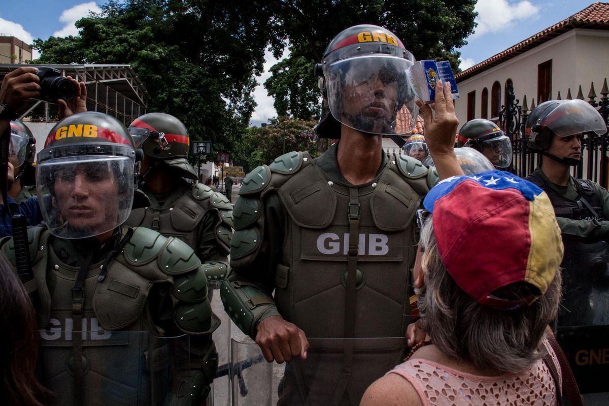Una manifestante grita consignas frente a integrantes de la Guardia Nacional Bolivariana durante una manifestación en Caracas (Venezuela)