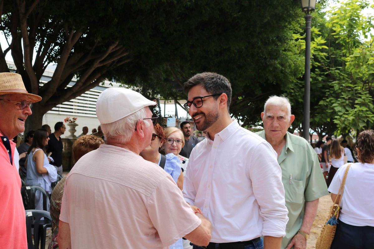 Mompó saluda a uno de los asistentes el acto.