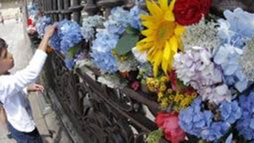 Un niño deposita unas flores en la catedral de Santiago.