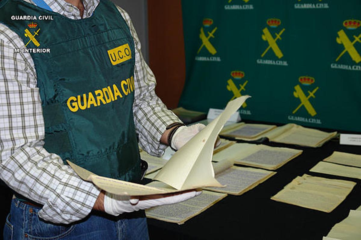 Material. Un agente de Patrimonio Histórico examina parte de los documentos intervenidos en Valencia.