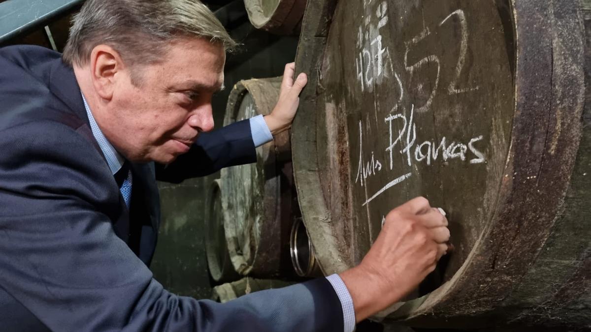 Luis Planas firma en una de las barricas de Toro Albalá.