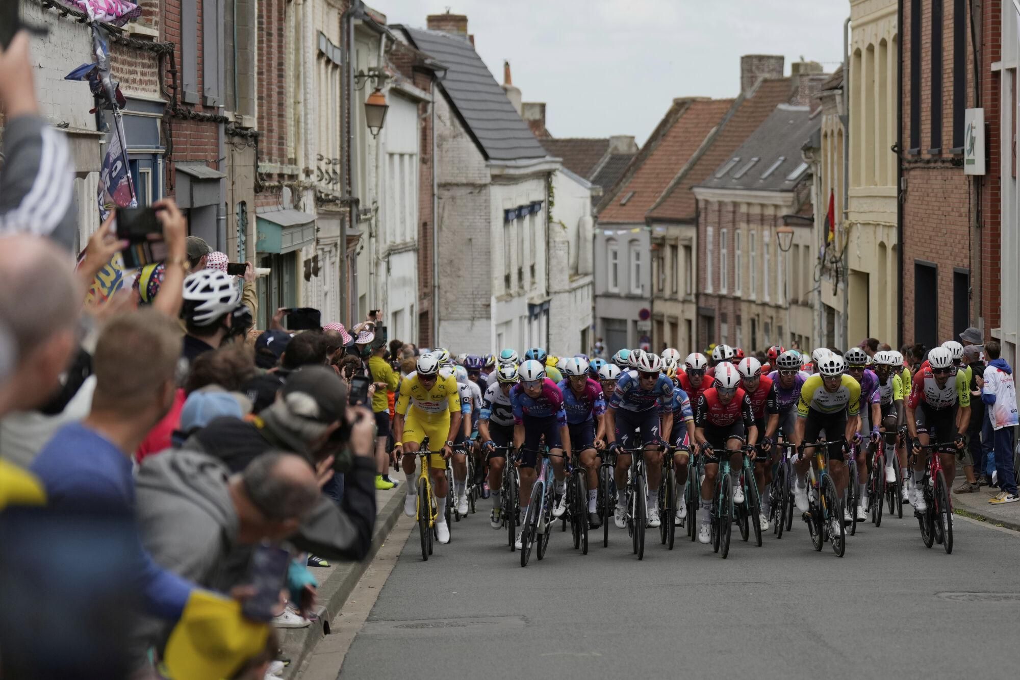 The pack rides during the third stage of the Tour de France cycling race over 178.3 kilometers (110.8 miles) with start in Valenciennes and finish in Dunkerque, France, Monday, July 7, 2025. (AP Photo/Mosa'ab Elshamy)