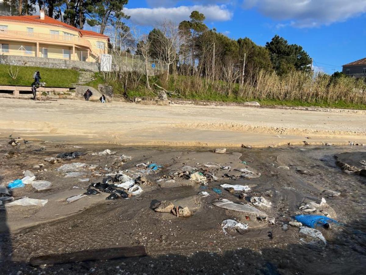 Bolsas de plástico, botellas y sacos de escombros en la arena. |   // G.N.