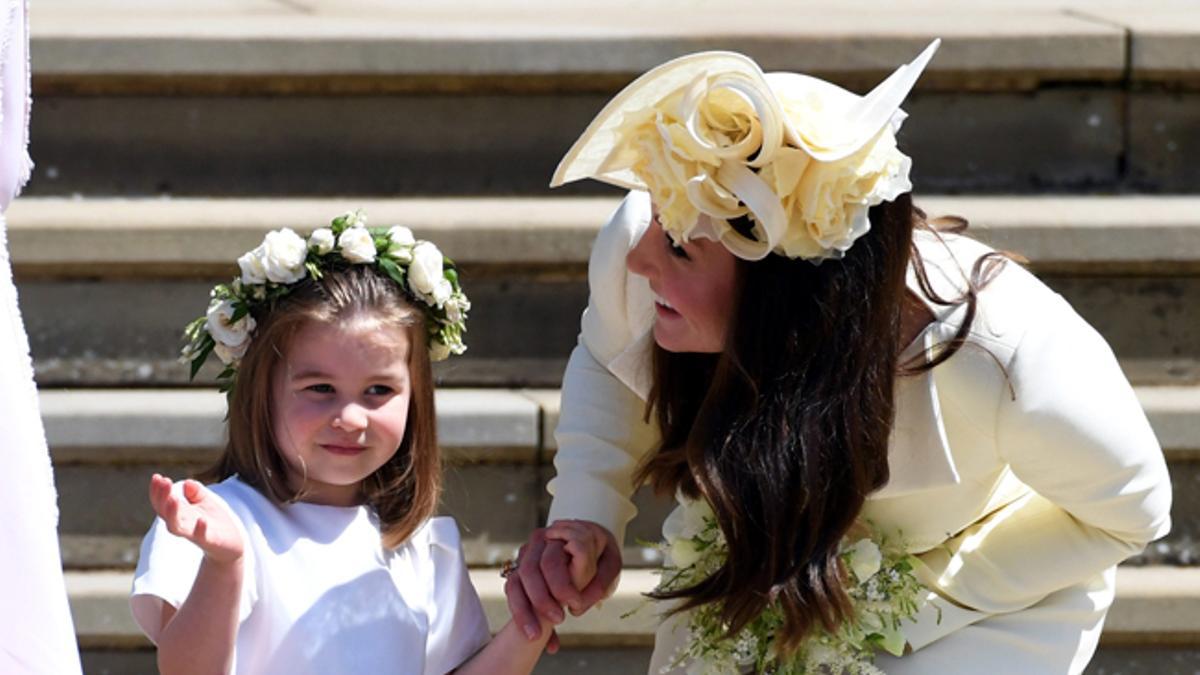 Kate Middleton se agacha para hablar con la princesa Charlotte en la boda del príncipe Harry y Meghan Markle