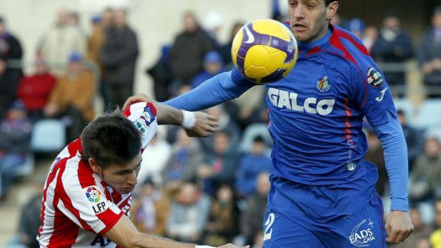 El defensa rumano del Getafe, Cosmin Contra (d); lucha por la posesión del balón contra el centrocampista del Sporting Pedro Santa Cecilia (i); durante el encuentro correspondiente a la vigésima jornada de la Liga de Primera División que ambos equipos disputan esta tarde en El Coliseum Alfonso Pérez de Getafe. EFE/Gustavo Cuevas