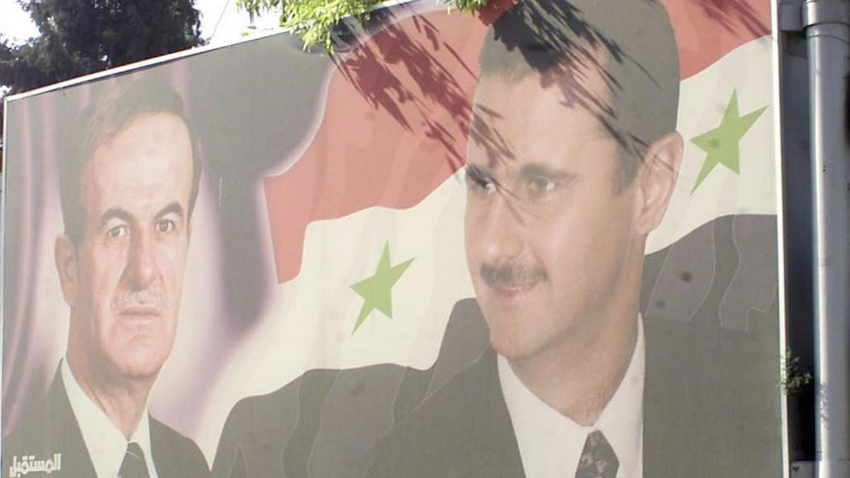 Un cartel con la imagen de Hafez y Bashar el Asad en Damasco.