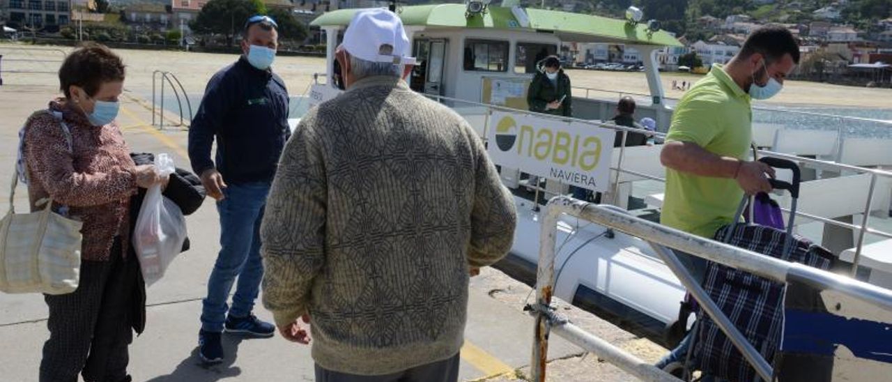 Vecinos y visitantes embarcan ayer en el muelle de Bueu para dirigirse hacia la isla de Ons.   | // GONZALO NÚÑEZ