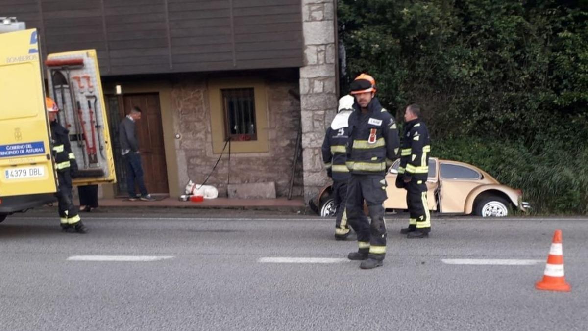 Un vecino y los bomberos, junto al vehículo siniestrado. | SEPA