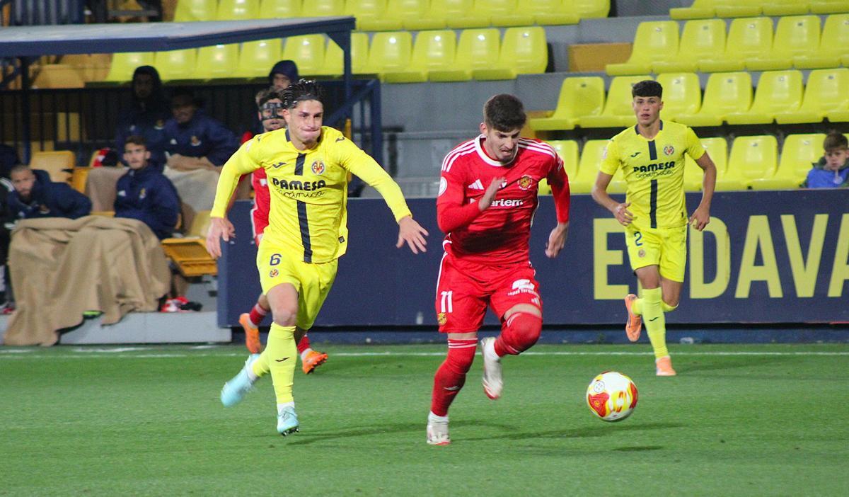 El jugador del Villarreal B persigue al del Nàstic.