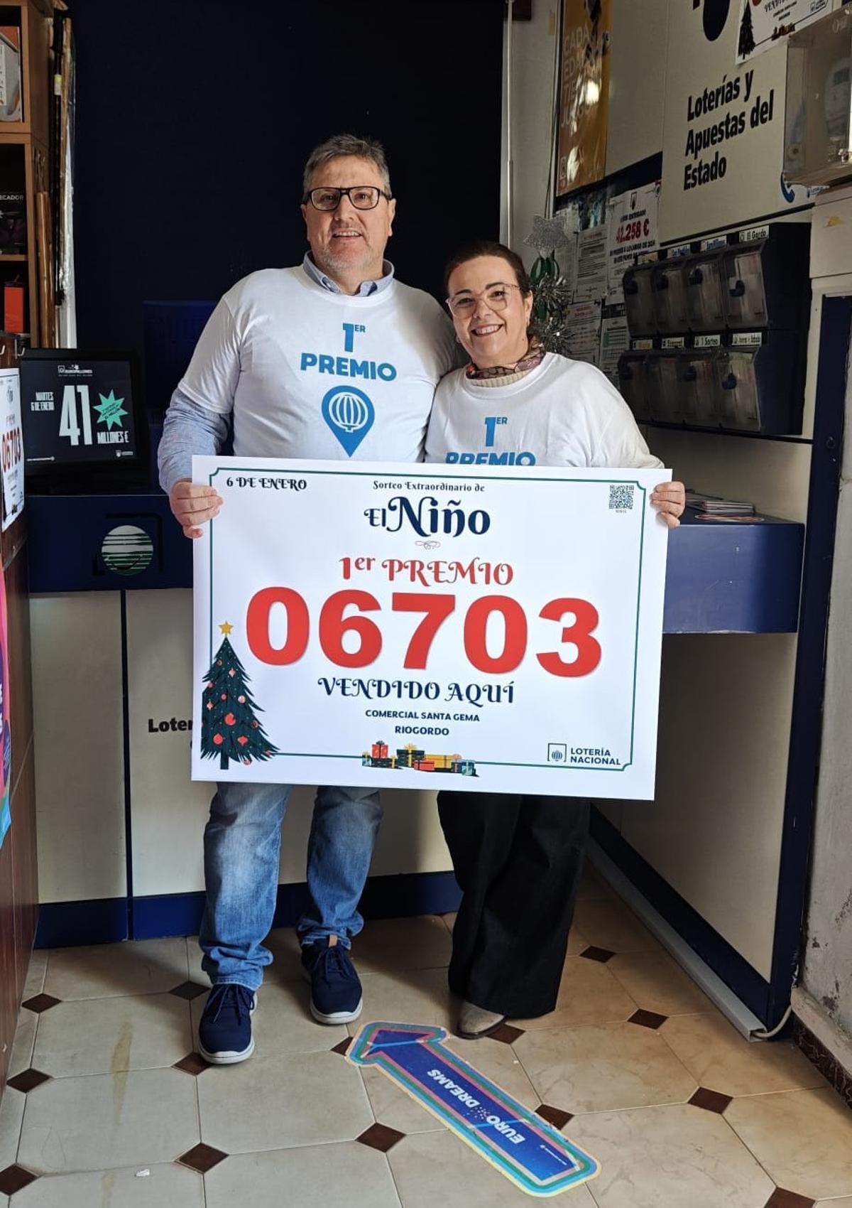 Alicia Ortega con el cartel del 06703, número premiado con el primer premio de la Lotería del Niño, del que se ha vendido un décimo en Riogordo.