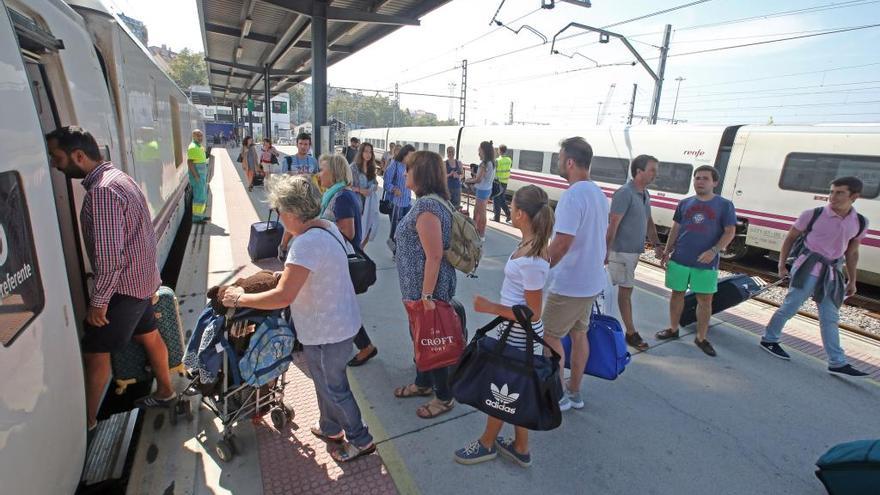 Pasajeros subiendo a un tren destino Madrid en Guixar. // Marta G. Brea