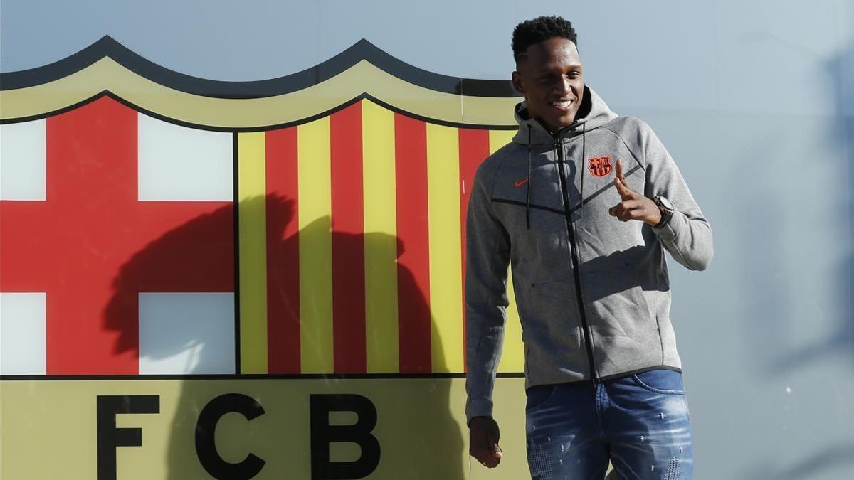 Yerry Mina posa ante el escudo del club.