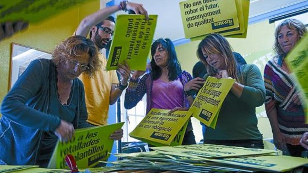Sindicalistas de USTEC preparan, ayer en Barcelona, carteles para la huelga de hoy.