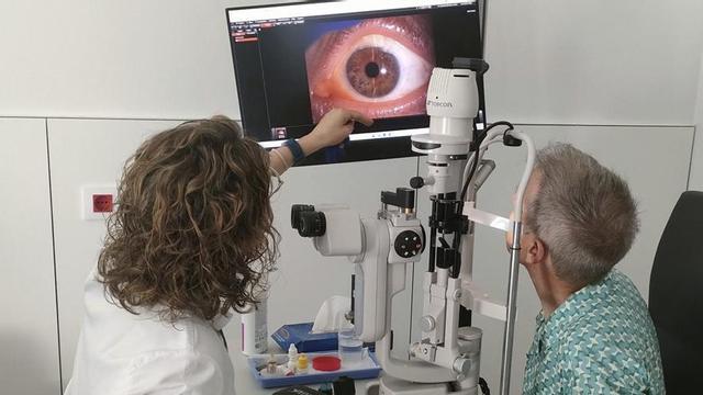 Una oftalmòloga revisa la visió a un pacient.