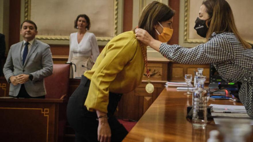 Patricia Hernández pone la medalla de concejal a Evelyn Alonso ante la mirada de José Manuel Bermúdez.