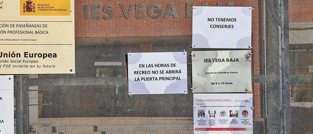 Acceso al IES Vega Baja con los carteles que advierten de la carencia de personal. |