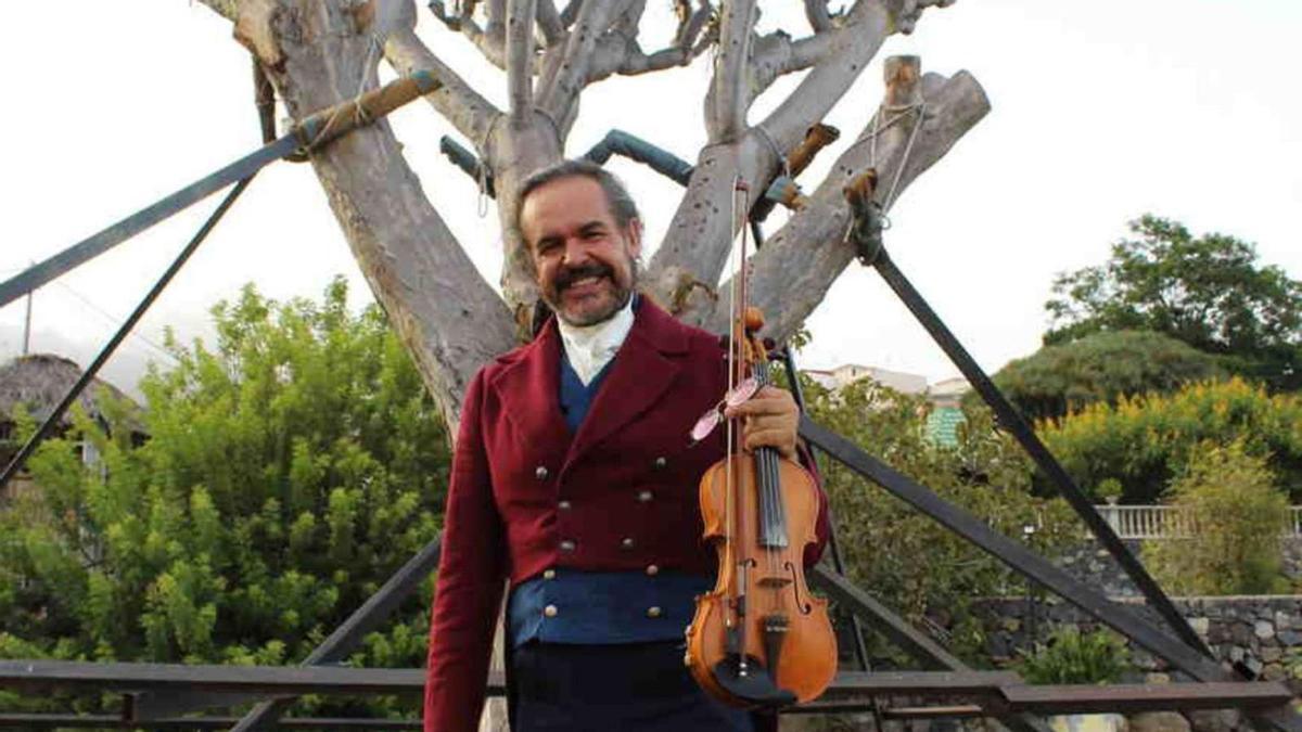 El hotelero y violinista Mario Díaz posa junto al drago de 103 años que rescató.