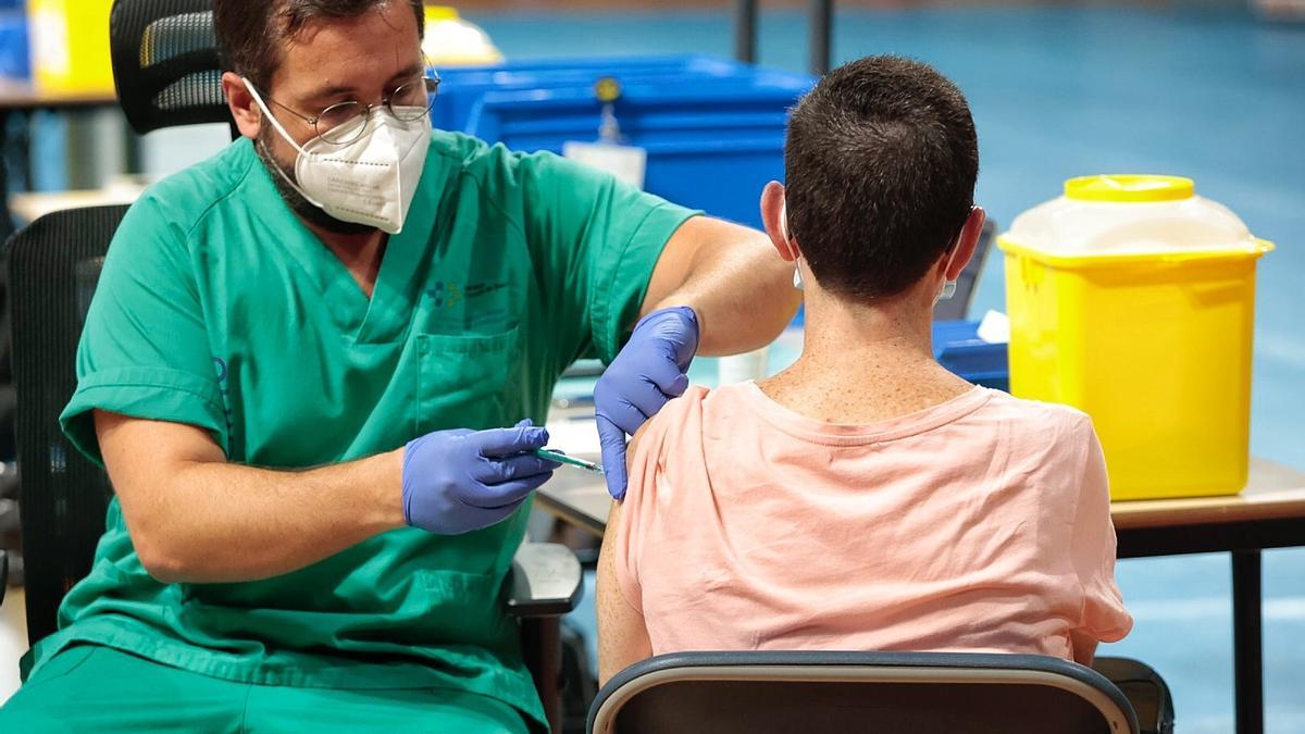 Un sanitario administra una dosis de la vacuna contra el coronavirus en el Pabellón Santiago Martín.