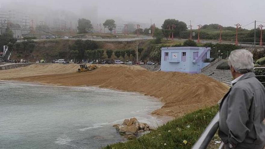 Un vecino observa las tareas de relleno de la playa de San Amaro. / juan varela