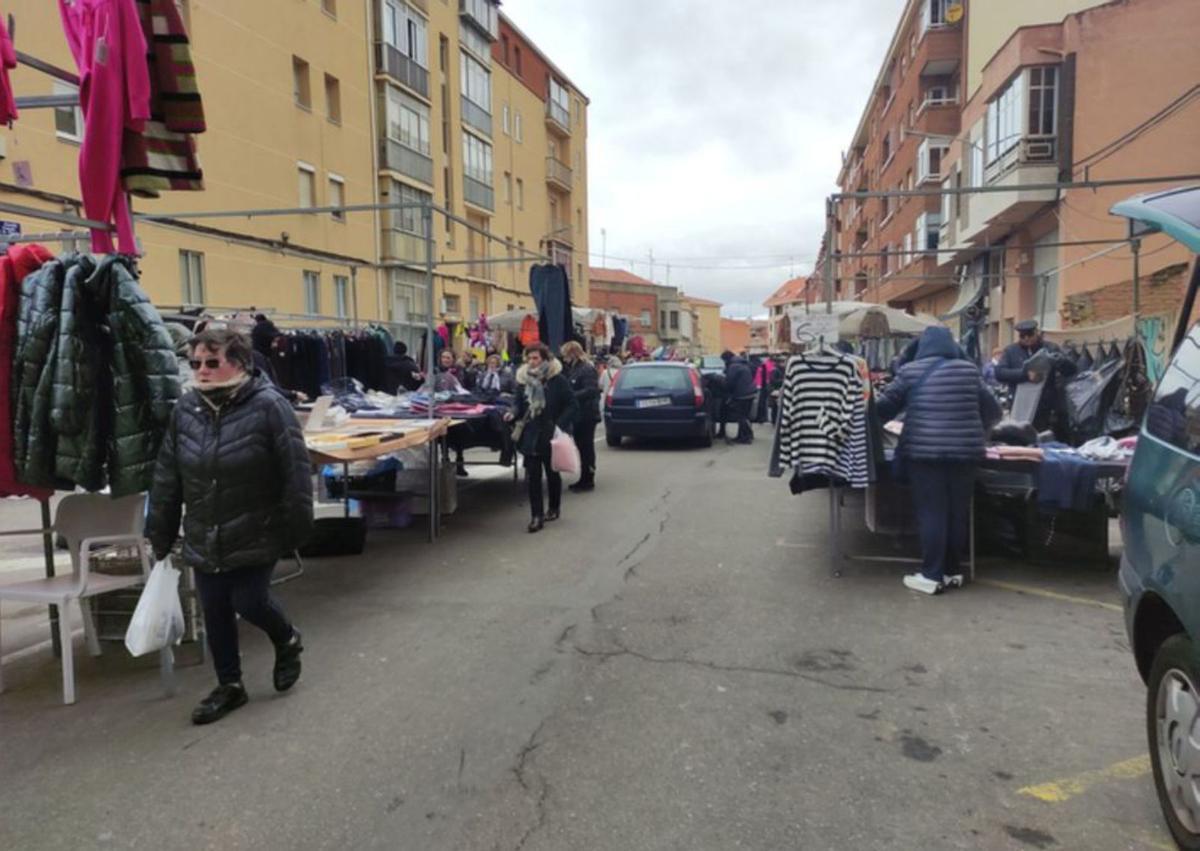 Algunos vecinos apurando las compras en el mercadillo, mientras los vendedores recogen los puestos. | E. P.