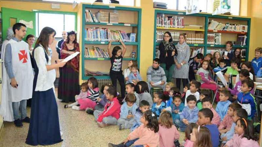 Los escolares atienden la lectura de un cuento.