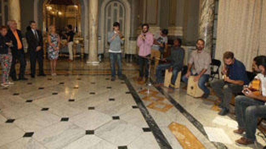 Los concejales del ayuntamiento escuchan a los músicos en el Salón de Cristal.