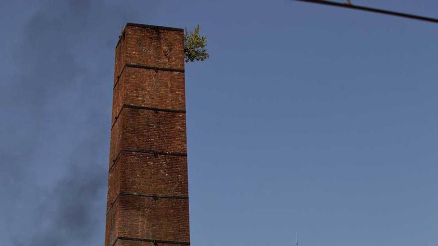 Dos chimeneas conservadas en La Felguera, con la térmica al fondo.