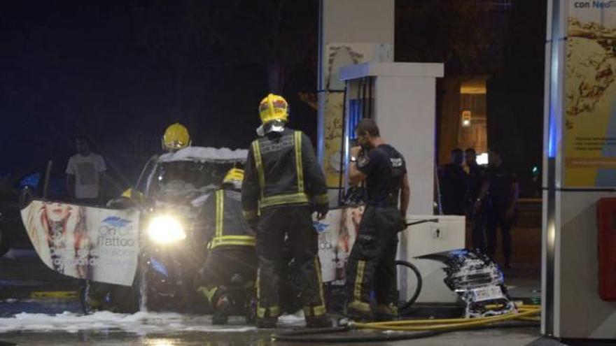 Los bomberos trabajan en el vehículo siniestrado, que quedó envuelto en llamas.