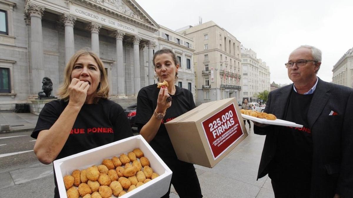 Los promotores de Change.org reparten coroquetas en la puerta de Leones del Congreso de los Diputados.