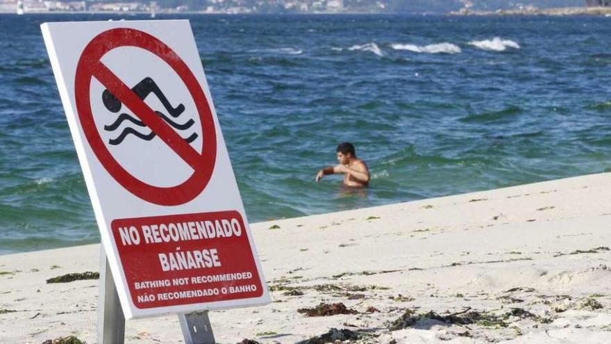 Un cartel colocado ayer en la playa de Canido que recomienda no bañarse. // José Lores