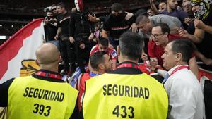 El futbolista Koke conversa con radicales, algunos con camisetas del Frente Atlético, durante la interrupción del derbi madrileño por el lanzamiento de objetos al campo.