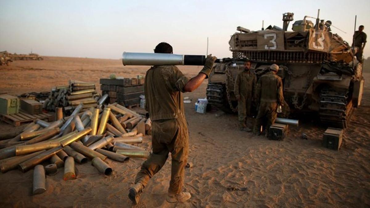 Un soldado israelí carga un obús para un tanque.