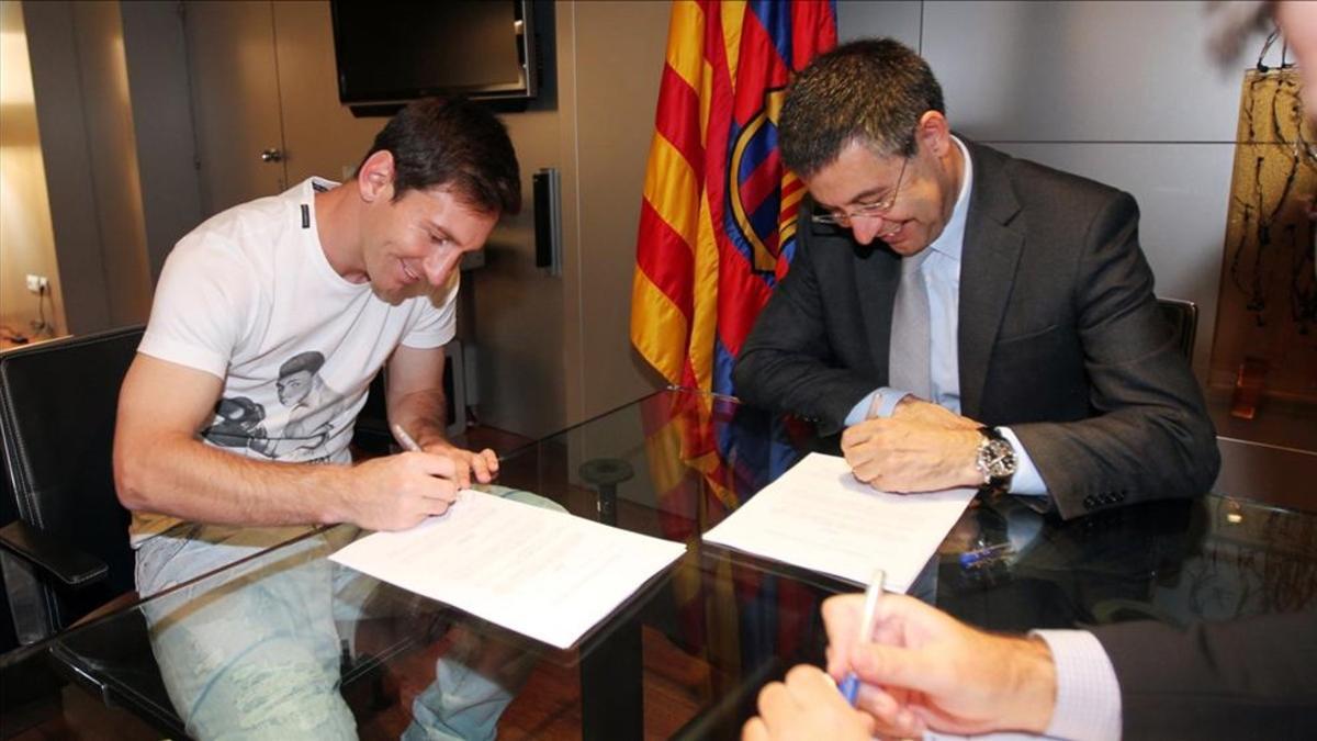 Leo Messi y Josep Maria Bartomeu, en la firma del último contrato del astro argentino